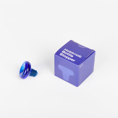 Blue Areaware Hobknob Bottle Stopper with its blue box beside it