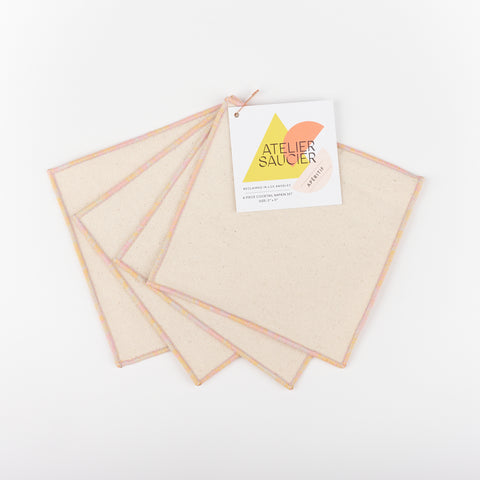 Atelier Saucier ivory colored set of cocktail napkins with soft pink, orange and purple edges