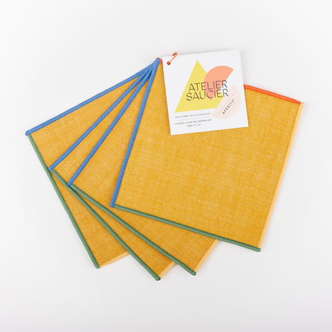 Set of four Atelier Saucier bright yellow cocktail napkins with blue, yellow, red and green edges