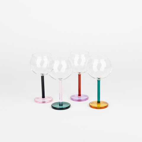 four Sophie Lou Jacobsen Bilboquet wine glasses with different colored glass bases and stems