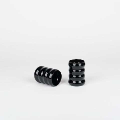 Set of Sopie Lou Jacobsen black opaque ripple cups, one laying down and one standing up