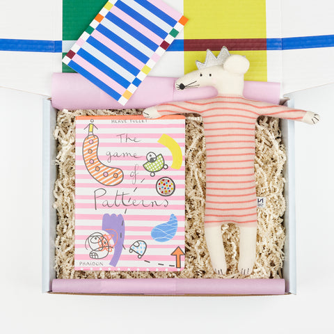 a children's gift box with the book The Game of Patterns and a stuff animal mouse with a pink striped body and a silver crown by Sophie Home Kids
