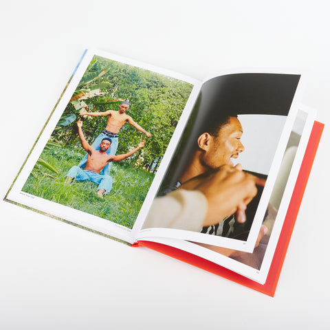 an open view of the book Love Songs Photography and Intimacy showing photographs of two men holding hands and smiling in