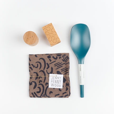 Areaware Pattern Salt and Pepper Shakers, a set of Blue Abyss colored Bamboo serving spoons, and a walnut and black patterned Jenny Pennywood cotton linen Everywhere Square