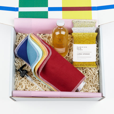 an open gift box with a bottle of Fillaree hand soap, a roll of re-usable cloth paper towels in assorted colors and a set of metallic colored lurex sponges
