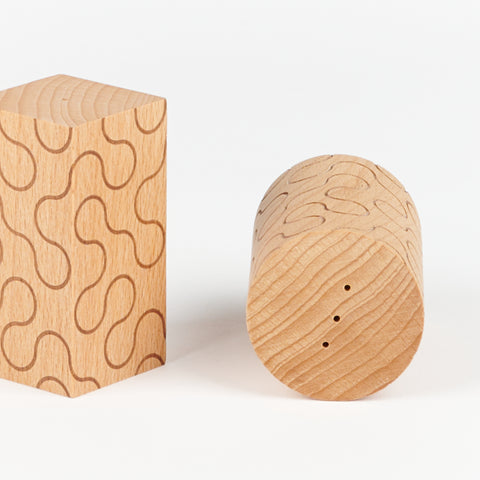 close up of the top and side of wooded salt and pepper shakers one is square shaped and one is round