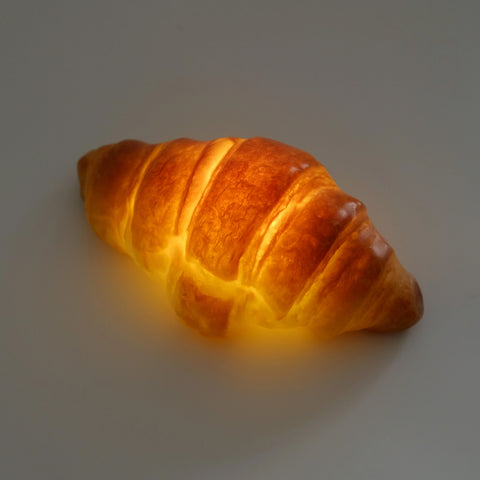 a small glowing lamp in the shape of a croissant
