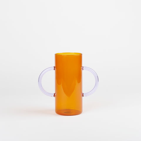 A deep orange borosilicate glass vase with matching curved lilac glass handles
