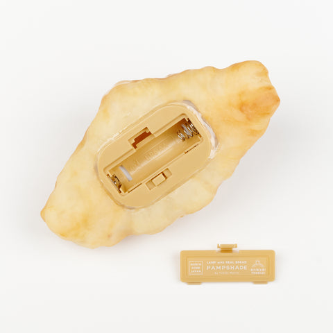 The underneath side of a bread lamp where the battery is inserted to light up this table lamp