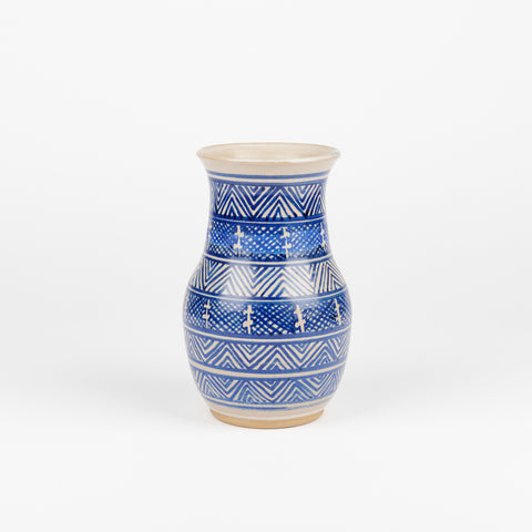 a vintage ceramic vase with bands of varying blue line patterns from top to bottom