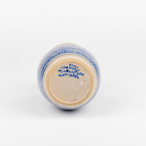 a vintage ceramic vase on its side showing the bottom of the vase with handwritten blue marks