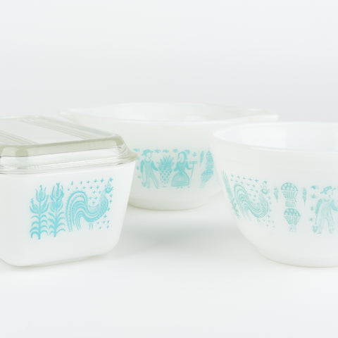 close up view of vintage white pyrex serving bowl set with light blue farm themed decorative pattern