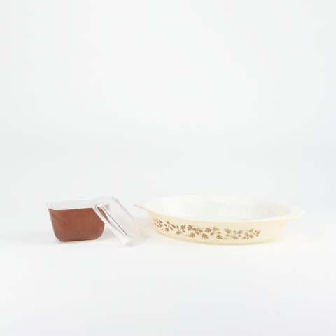Vintage set of two Pyrex serving dishes. One is smaller and comes with a glass lid and the other is larger and has a brown oak leaf design on it