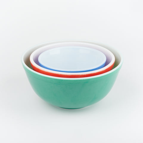 nested view of three vintage Pyrex bowls in green, red, and blue
