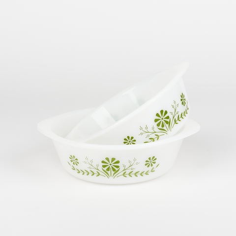 Two vintage glasbake white casserole dishes one dish is sitting inside of the other and sticking out at an angle