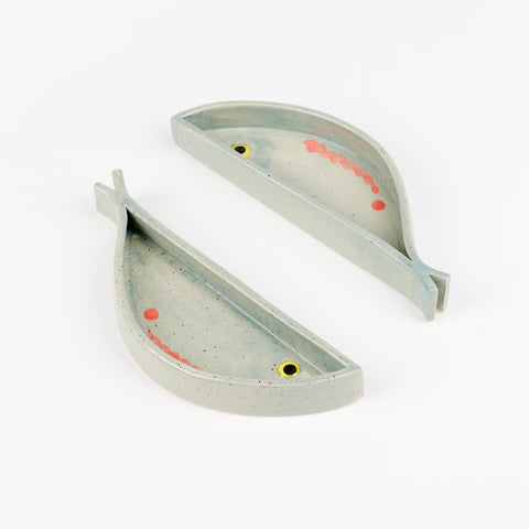 A side view showing two fish shaped ceramic dishes and their depth