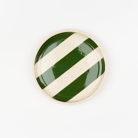 A single ceramic side place with a speckled surface and hunter green stripes