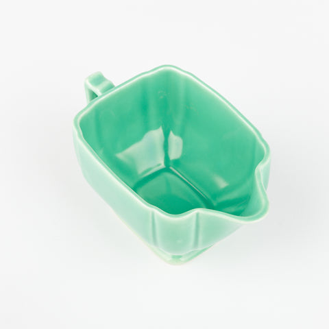 top down view of the inside of a mint green creamer dish