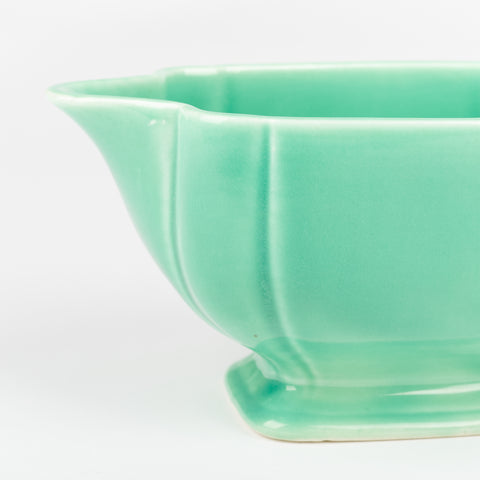 side profile view of mint green vintage ceramic riviera ware creamer dish showing pour spout and foot