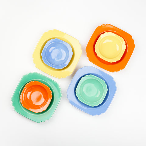 top down view of colorful vintage bowl set which includes four large and four small bowls with decorative edges