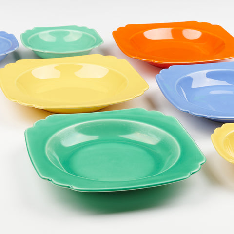 side view close-up of colorful vintage ceramic riviera ware bowls green yellow red and blue