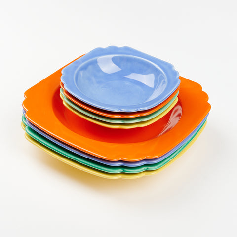 a stack of large and small vintage ceramic bowls this is an intentionally mismatched colorful set of tableware