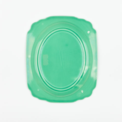 the backside of a green ceramic vintage serving dish with a few slight blemishes