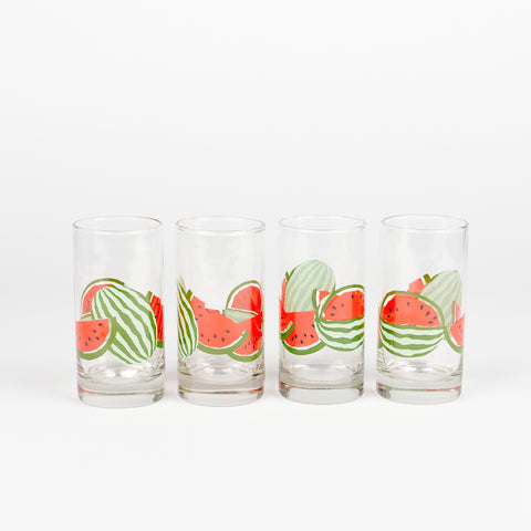 a line of four vintage drinking glasses with watermelon pattern going around the glasses