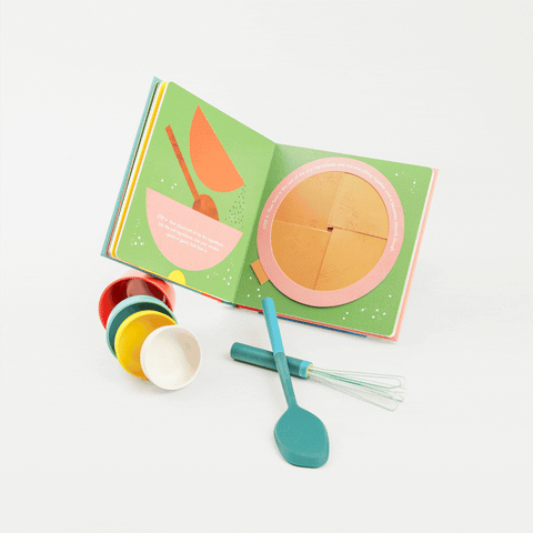 Four primary color measuring cups, a mini blue whisk and spatula and a interactive Cookies! book showing an interactive page of cookie dough being mixed
