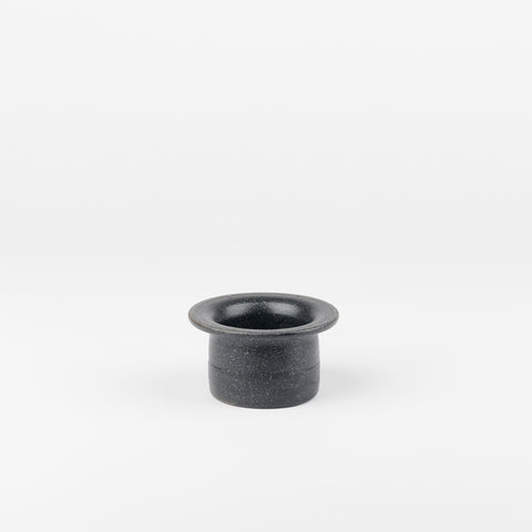 a black ceramic tea strainer handmade by Utility Objects standing upright