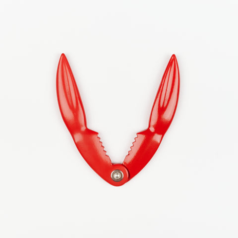 an open bright red metal crab claw used for cracking shells