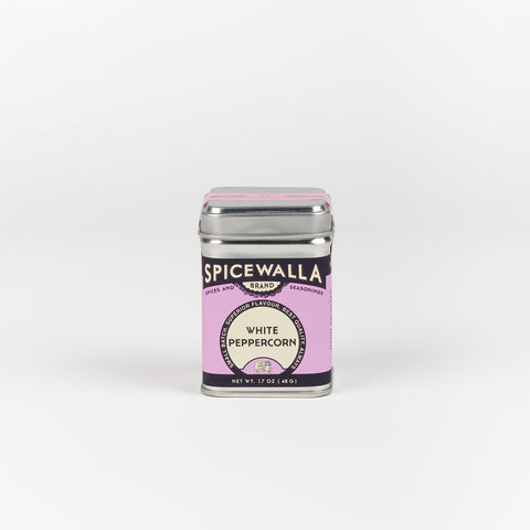 A squarish small metal tin of white peppercorns