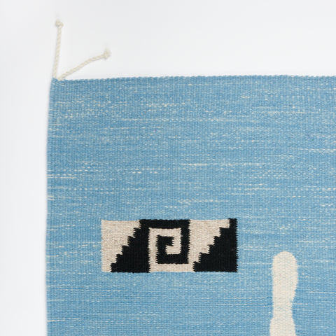 detail of a handwoven blue rug with a geometric face designed by Amanda Barr