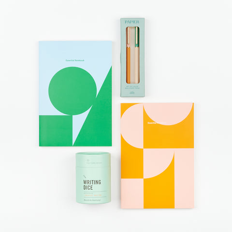 A gift set which includes two Poketo lined notebooks, a set of Papier ballpoint pens and Writing Dice to provide inspiration for creative writing