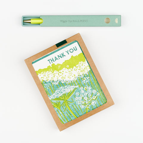 A gift set that includes a Box of Thank You Cards with green floral Queen Anne's Lace theme and a green box with a yellow pen inside it