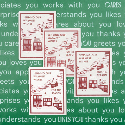 Set of four Heartell Press blank holiday note cards each with an illustration featuring red houses in snow