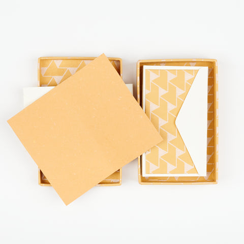 an open box of Hataguchi Collective orange blank notecards with a geometric print