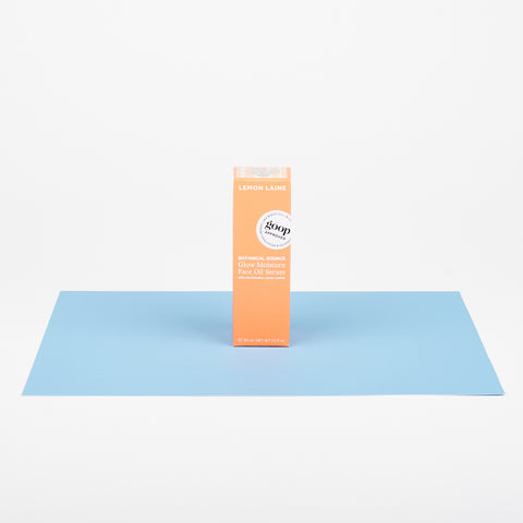 small peach colored box of Lemon Laine face oil on a plane of light blue color