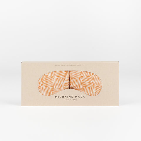 A Slow North Migraine Eye mask with a orange copper cross hatch gridded pattern