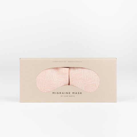 A Slow North Migraine Eye mask with a pink cross hatch gridded pattern