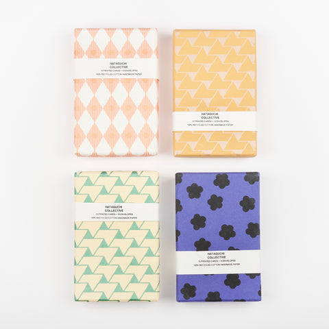 Four boxes of orange, green, blue and copper Hataguchi Collective cards