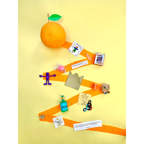 A TOPS Malibu Orange themed surprise ball unpeeling and showing the prizes that are hidden inside.