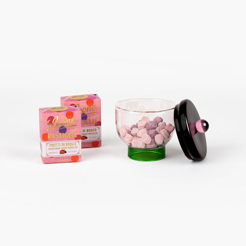 Front view of Eye Candy gift set showing Sophie Lou Jacobsen glass bowl half-filled with Leone candies and two wrapped candy boxes on a white background.