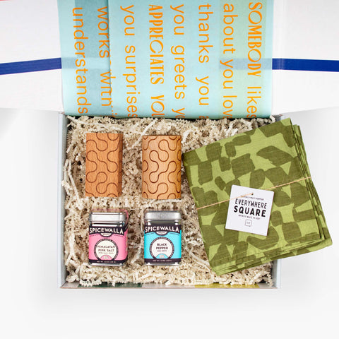 hake It Up gift set with Jenny Pennywood Everywhere Square textile in green, Dusen Dusen wooden salt and pepper shakers, and Spicewalla spices, arranged in an open gift box.