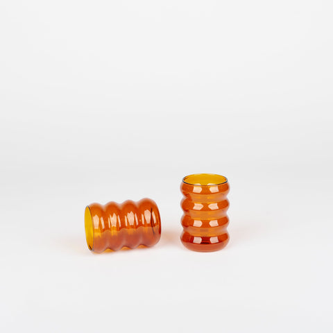 a pair of Sophie Lou Jacobsen amber Ripple Cups with one on its side