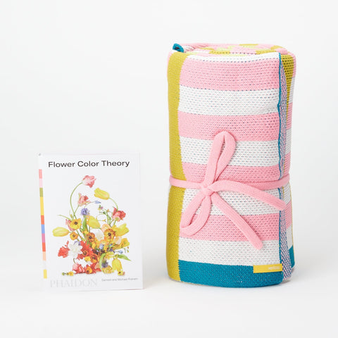 Flower Color Theory book and Veriloop pink, white, blue and green striped blanket both standing up