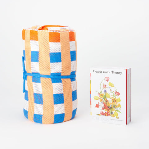 Flower Color Theory book and Veriloop blue, orange, red and white blanket both standing up
