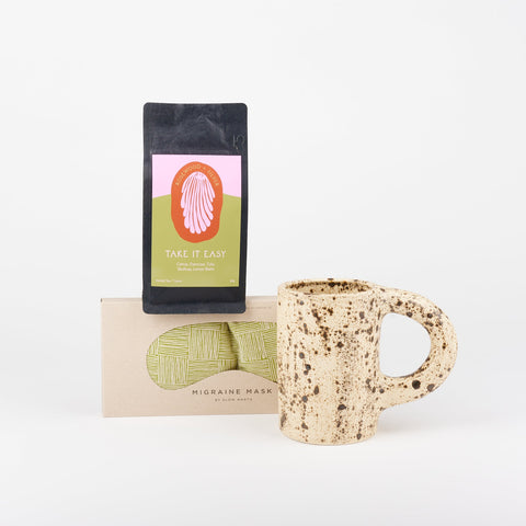 A Slow North Migraine Eye Mask, Utility Objects Eggshell Speckled Ceramic Mug, and Rosewood and Silver Take It Easy loose leaf tea