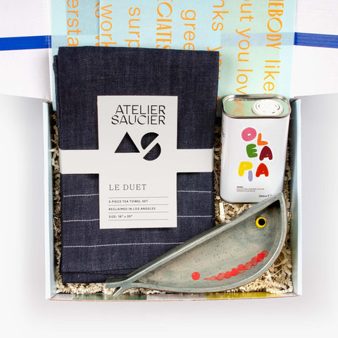 Form and Flavor gift set with LH Ceramics anchovy dish, Atelier Saucier tea towel set, and Olea Pia EVOO tin arranged in a gift box.