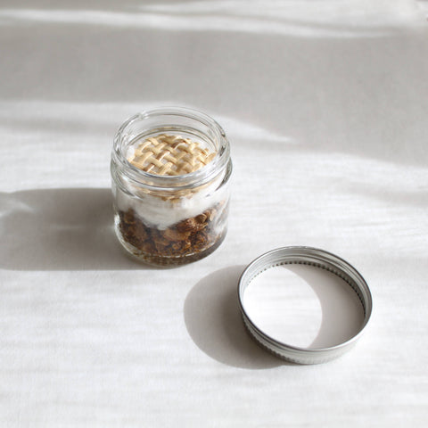 Glass jar with lid on a light gray surface